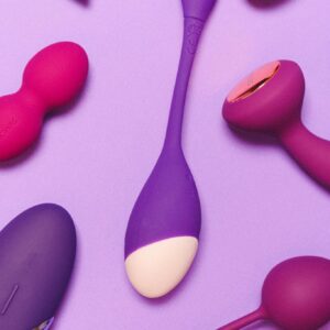 A collection of vibrant silicone sex toys displayed on a purple surface, emphasizing pleasure and intimacy.