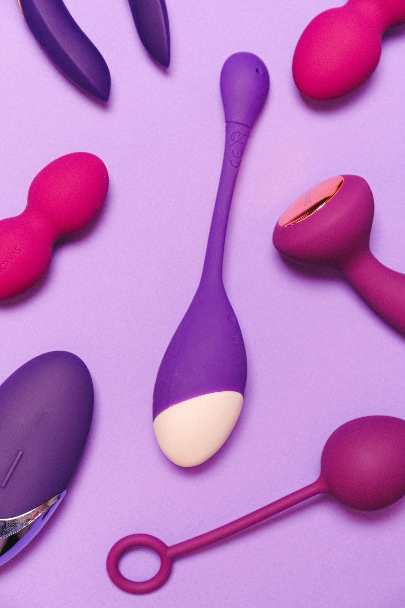 A collection of vibrant silicone sex toys displayed on a purple surface, emphasizing pleasure and intimacy.