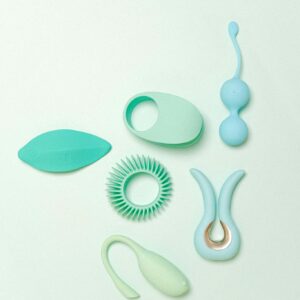 Collection of turquoise silicone sex toys arranged on a light background, showcasing different designs.