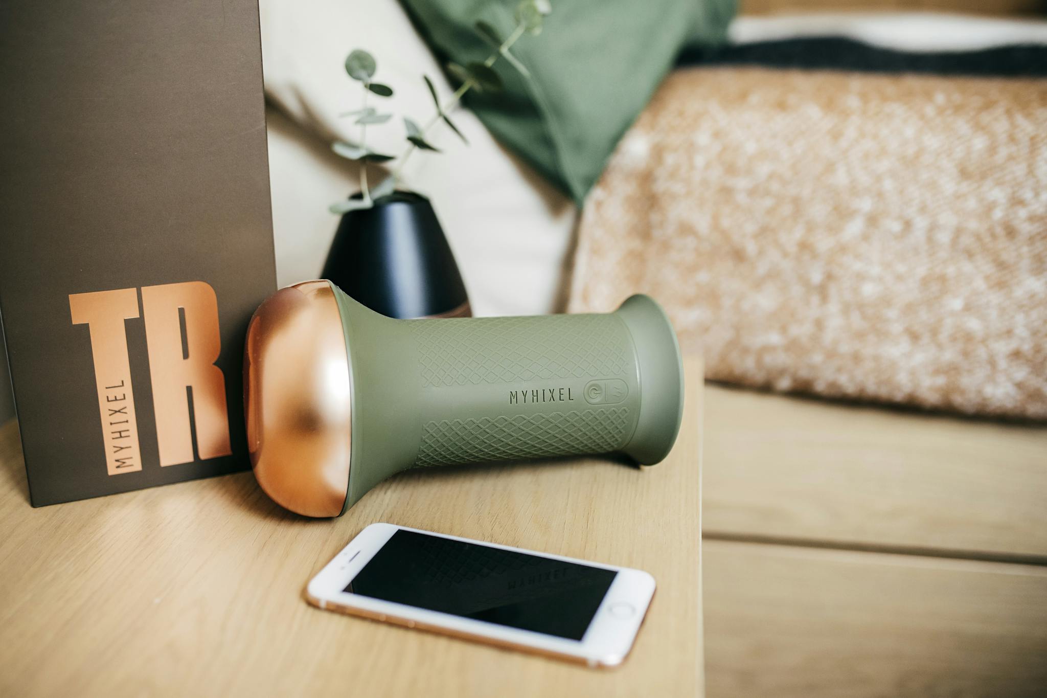 Myhixel TR device alongside packaging and smartphone on a bedside table.