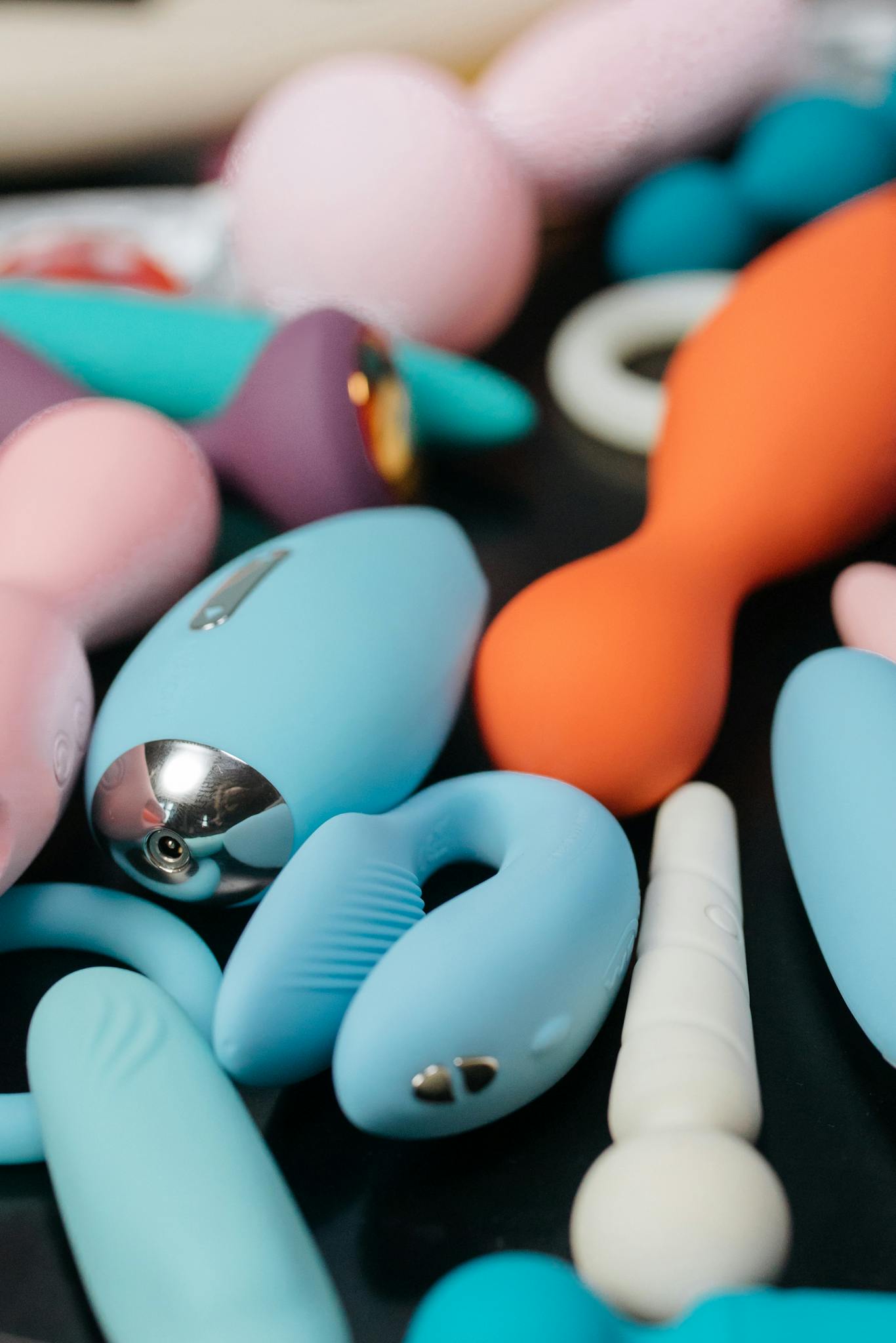 Our Mission Vibrant close-up of assorted sleek and modern sex toys, showcasing different shapes and colors.
